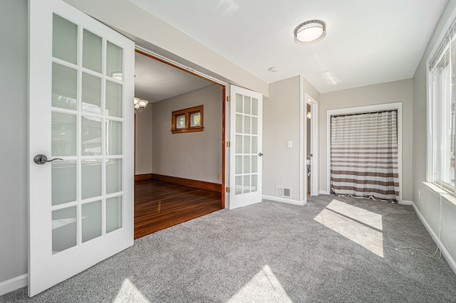50 Elm St, River Rouge, MI 48218 - carpeted empty room with french doors, baseboards, and a chandelier