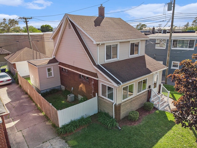 50 Elm St, River Rouge, MI 48218 - view of home's exterior featuring a chimney, a shingled roof, brick siding, and cooling unit