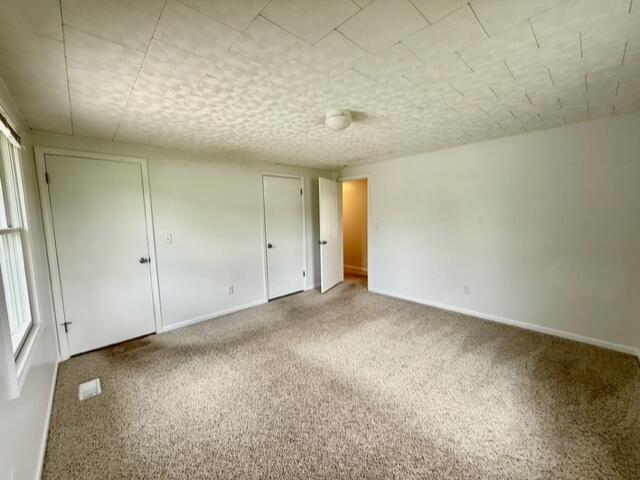 unfurnished bedroom with carpet flooring, baseboards, and a closet