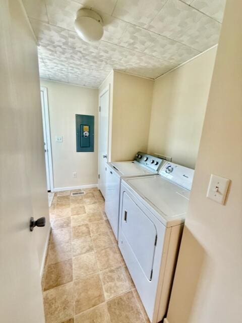 laundry room featuring electric panel, washer and clothes dryer, and baseboards