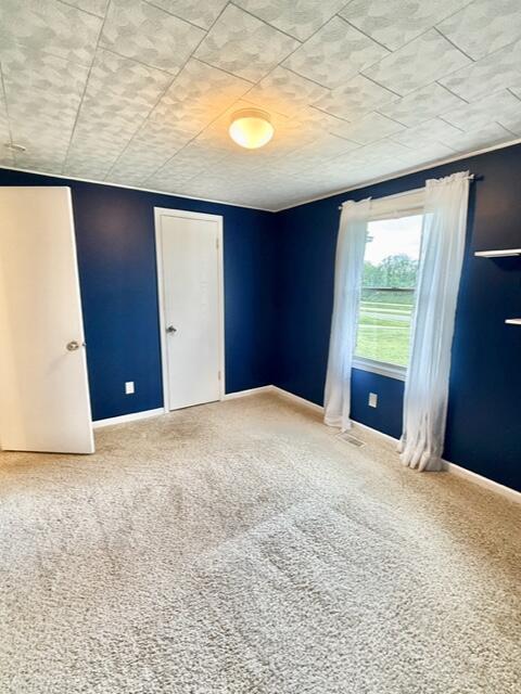 carpeted spare room with baseboards