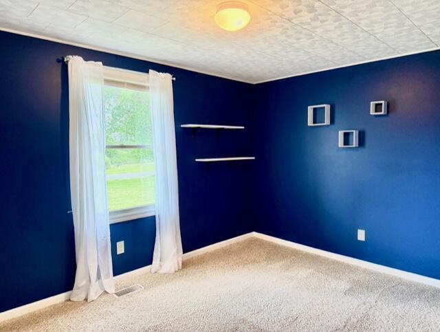 spare room with carpet and baseboards