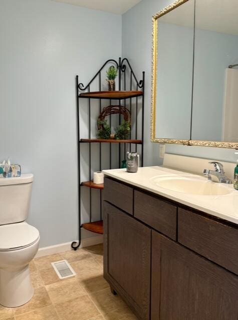 full bath featuring toilet, vanity, and baseboards