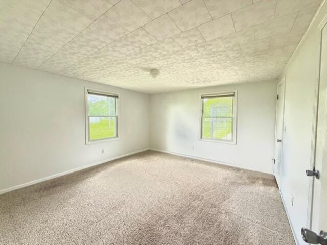 carpeted spare room with healthy amount of natural light and baseboards
