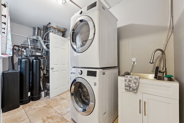 1255 Meadowood Dr, Waterford, MI 48327 - washroom featuring stacked washing machine and dryer, cabinet space, and light tile patterned flooring