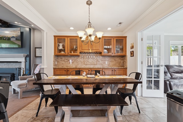 1255 Meadowood Dr, Waterford, MI 48327 - dining room with a chandelier, crown molding, a tiled fireplace, recessed lighting, and light tile patterned flooring