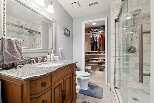 1255 Meadowood Dr, Waterford, MI 48327 - bathroom featuring tile patterned floors, toilet, vanity, a shower stall, and a spacious closet