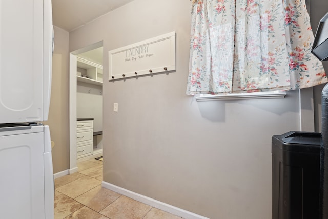 1255 Meadowood Dr, Waterford, MI 48327 - washroom featuring stacked washer and clothes dryer, light tile patterned floors, and baseboards