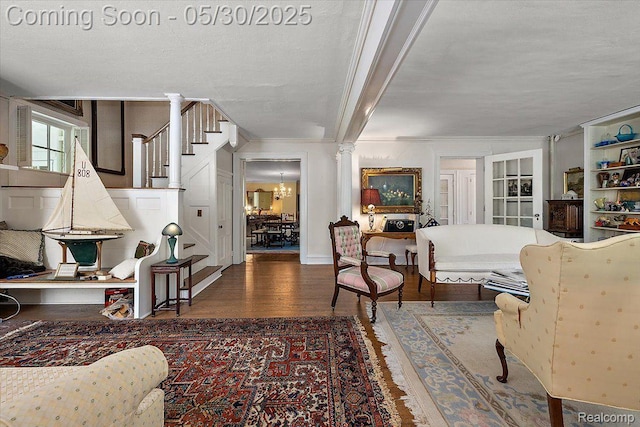16109 E Jefferson Ave, Grosse Pointe Park, MI 48230 - living room with wood finished floors, stairs, crown molding, decorative columns, and a chandelier