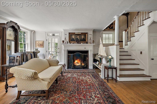 16109 E Jefferson Ave, Grosse Pointe Park, MI 48230 - living room featuring wood finished floors, ornamental molding, a warm lit fireplace, stairway, and a textured ceiling
