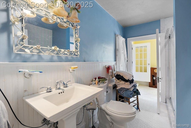 16109 E Jefferson Ave, Grosse Pointe Park, MI 48230 - bathroom featuring wainscoting, toilet, and a textured ceiling