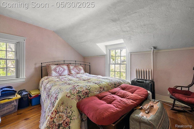 16109 E Jefferson Ave, Grosse Pointe Park, MI 48230 - bedroom with radiator, hardwood / wood-style floors, lofted ceiling, multiple windows, and a textured ceiling