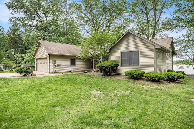 view of front of home featuring concrete driveway, a shingled roof, a front yard, and a garage