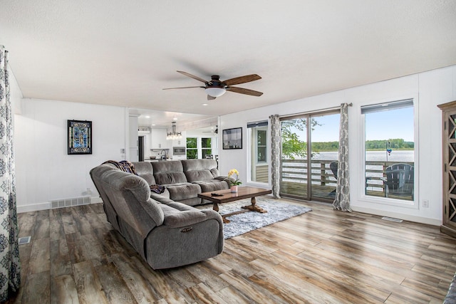 living room featuring a ceiling fan, wood finished floors, and baseboards