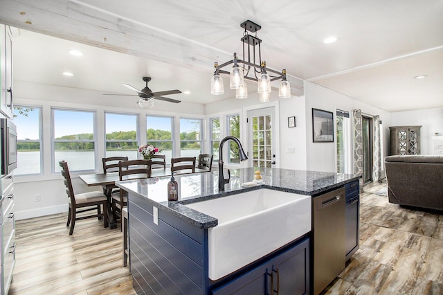 kitchen featuring a sink, healthy amount of natural light, open floor plan, stainless steel dishwasher, and recessed lighting