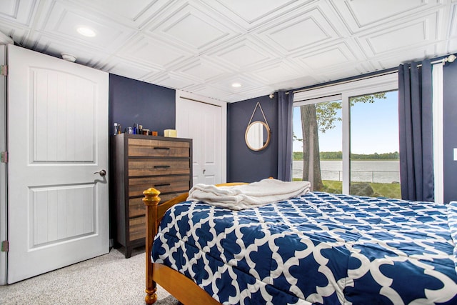 bedroom featuring recessed lighting, a water view, an ornate ceiling, light colored carpet, and access to exterior