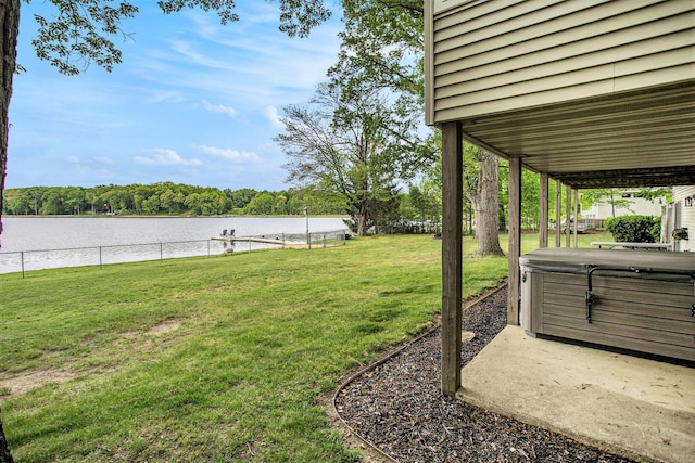 view of yard with a hot tub, a water view, and a patio