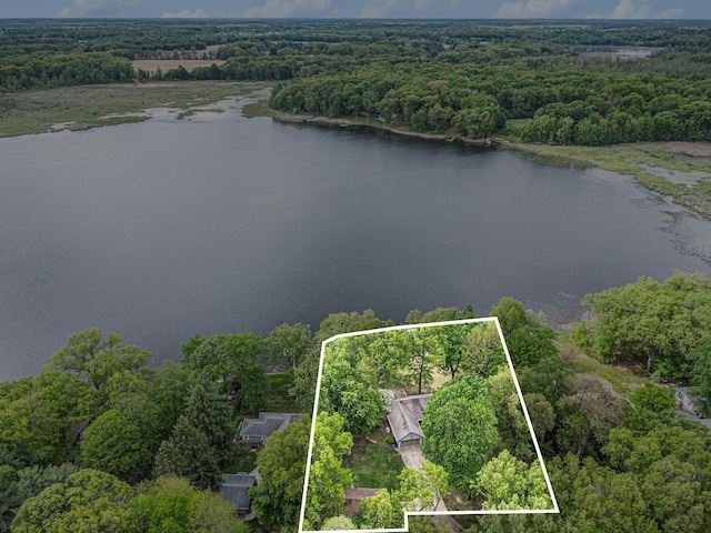 view of property location featuring a forest, a nearby body of water, and property parcel outlined
