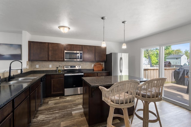 25596 Forest Dr, Mattawan, MI 49071 - kitchen with stainless steel appliances, a sink, dark wood-style flooring, dark brown cabinetry, and backsplash