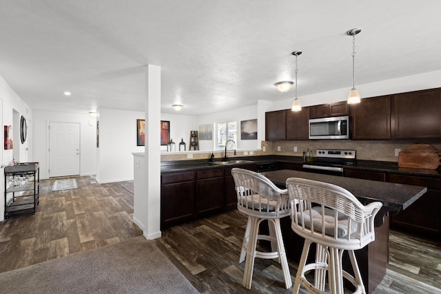 25596 Forest Dr, Mattawan, MI 49071 - kitchen featuring stainless steel appliances, a sink, dark countertops, and dark brown cabinetry