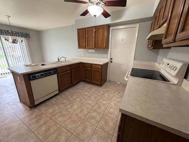20433 Birch Meadow Dr, Clinton Township, MI 48036 - kitchen featuring white appliances, under cabinet range hood, a peninsula, a sink, and light tile patterned floors