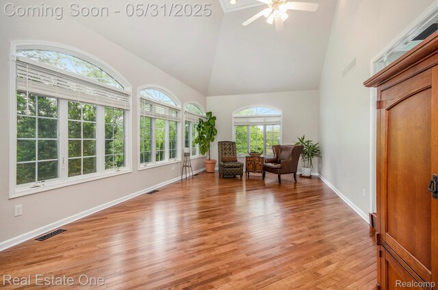 3088 Exeter Dr, Milford, MI 48380 - living area with high vaulted ceiling, light wood-style floors, a ceiling fan, and baseboards