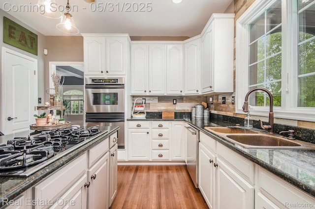 3088 Exeter Dr, Milford, MI 48380 - kitchen featuring appliances with stainless steel finishes, a sink, white cabinets, and light wood-type flooring