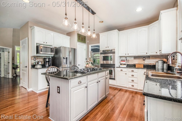 3088 Exeter Dr, Milford, MI 48380 - kitchen featuring a sink, appliances with stainless steel finishes, light wood finished floors, dark stone countertops, and recessed lighting