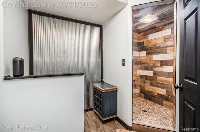 3088 Exeter Dr, Milford, MI 48380 - full bathroom featuring wood walls, a tile shower, and wood finished floors