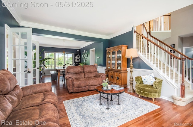 3088 Exeter Dr, Milford, MI 48380 - living area with ornamental molding, stairs, wood finished floors, french doors, and a wainscoted wall