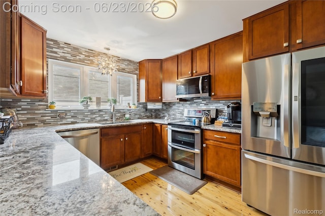 750 2nd St Unit 27, Wyandotte, MI 48192 - kitchen with stainless steel appliances, light wood finished floors, and tasteful backsplash