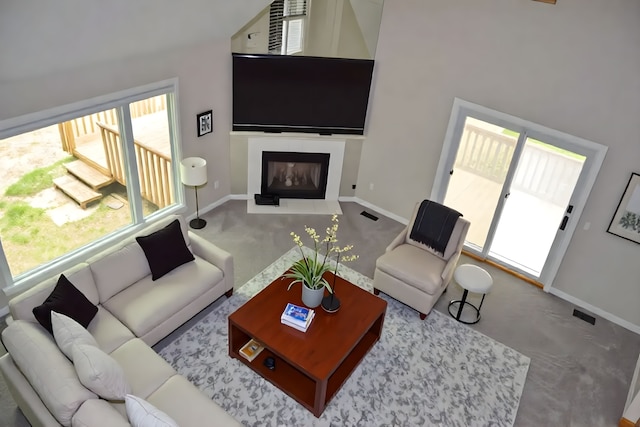 37695 Burton Dr, Farmington Hills, MI 48331 - carpeted living room with baseboards, a fireplace with flush hearth, and a towering ceiling