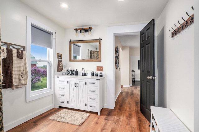 7917 E Harrison Rd, Breckenridge, MI 48615 - corridor featuring a sink, wood finished floors, baseboards, and recessed lighting