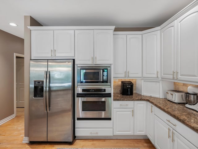 62887 Tournament Dr, Washington, MI 48094 - kitchen featuring appliances with stainless steel finishes, recessed lighting, dark stone countertops, white cabinetry, and decorative backsplash