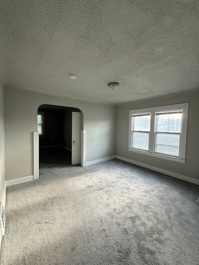 7130 Julian St, Detroit, MI 48204 - carpeted spare room featuring arched walkways, a textured ceiling, and baseboards