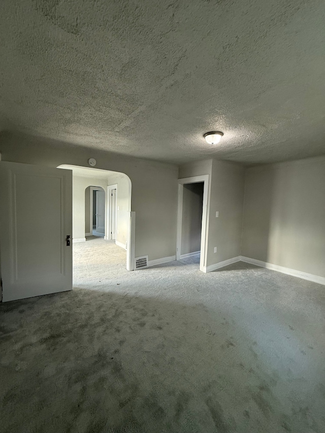 7130 Julian St, Detroit, MI 48204 - carpeted empty room featuring arched walkways, baseboards, and a textured ceiling