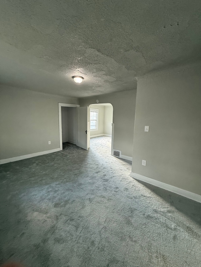 7130 Julian St, Detroit, MI 48204 - spare room featuring arched walkways, a textured ceiling, baseboards, and carpet