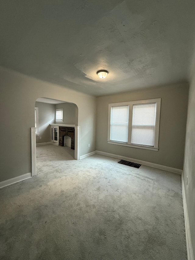 7130 Julian St, Detroit, MI 48204 - unfurnished living room with arched walkways, carpet floors, and baseboards