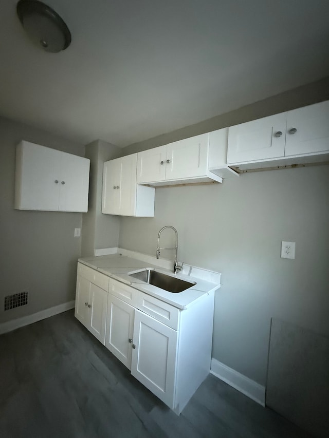 7130 Julian St, Detroit, MI 48204 - kitchen featuring a sink, baseboards, white cabinetry, and light countertops
