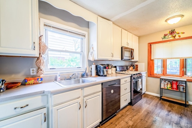 706 White Ave, Lincoln Park, MI 48146 - kitchen with black range with gas cooktop, stainless steel microwave, dishwashing machine, a sink, and white cabinetry