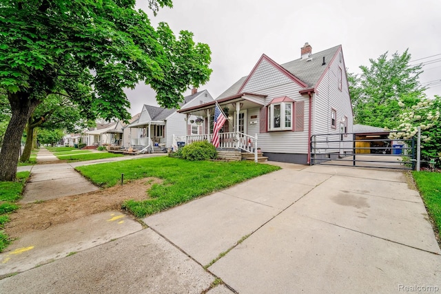 706 White Ave, Lincoln Park, MI 48146 - victorian house with a chimney, a porch, a front lawn, and a gate