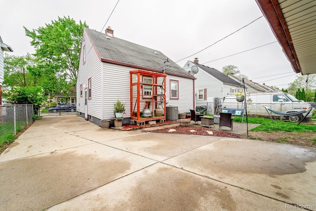 706 White Ave, Lincoln Park, MI 48146 - back of property with a shingled roof, central AC, a chimney, and a patio
