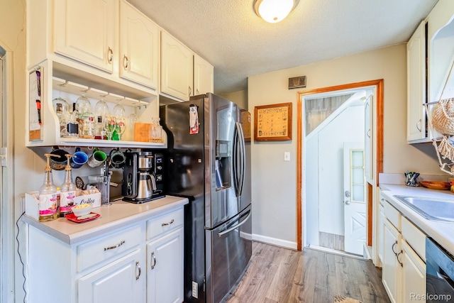 706 White Ave, Lincoln Park, MI 48146 - kitchen with stainless steel refrigerator with ice dispenser, dishwashing machine, a textured ceiling, light wood-style flooring, and light countertops