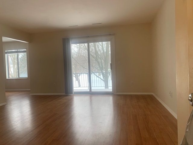 311 W Highland Rd Unit T13, Howell, MI 48843 - empty room featuring plenty of natural light, wood finished floors, and baseboards