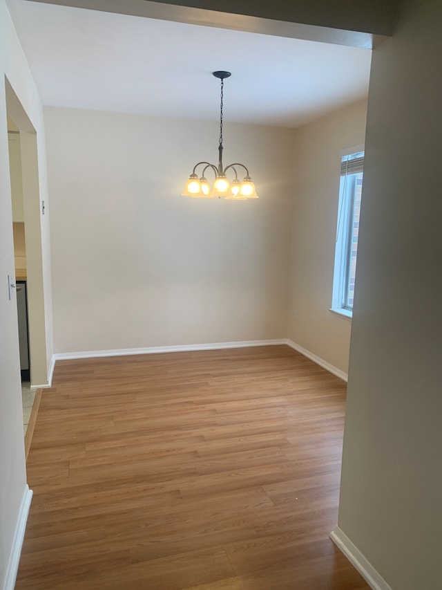 311 W Highland Rd Unit T13, Howell, MI 48843 - unfurnished dining area featuring light wood-style flooring, baseboards, and a chandelier
