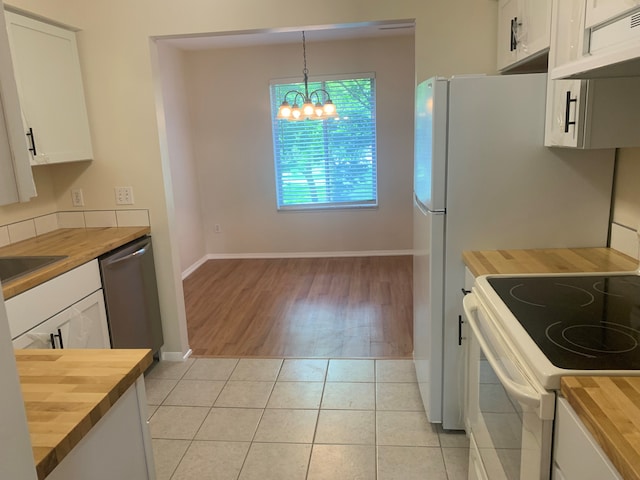 311 W Highland Rd Unit T13, Howell, MI 48843 - kitchen featuring wooden counters, white range with electric stovetop, dishwasher, a chandelier, and white cabinetry