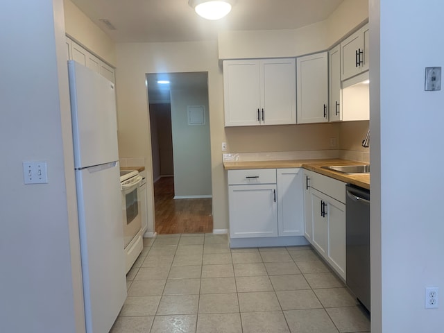 311 W Highland Rd Unit T13, Howell, MI 48843 - kitchen with white appliances, light countertops, light tile patterned floors, and white cabinetry