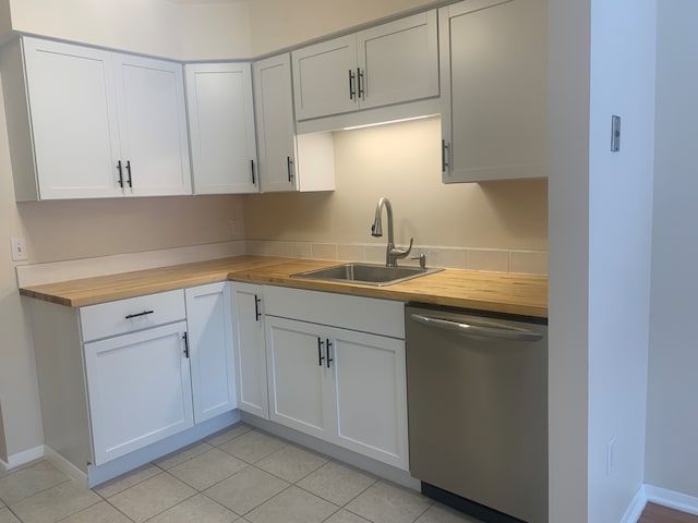 311 W Highland Rd Unit T13, Howell, MI 48843 - kitchen featuring butcher block countertops, stainless steel dishwasher, a sink, light tile patterned flooring, and baseboards