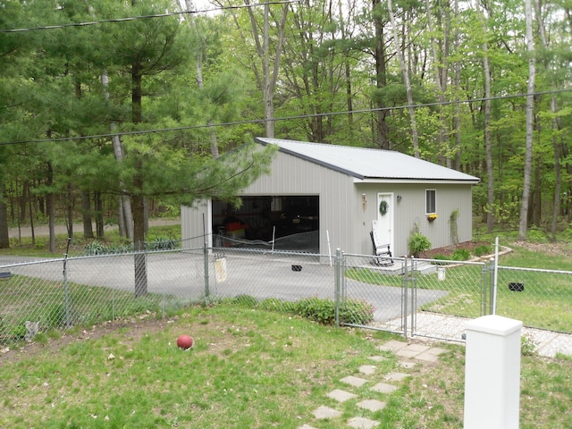 6515 Maple Rd, Ludington, MI 49431 - view of front facade with a detached garage, an outbuilding, and a wooded view