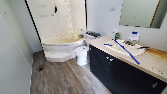 7939 W Moore Rd, Ravenna, MI 49451 - full bathroom with wood finished floors, toilet, vanity, and shower / washtub combination